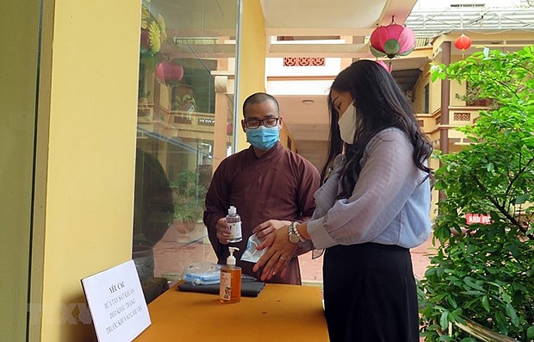 Người dân rửa tay sát khuẩn trước khi vào lễ chùa 2253-rua-tay