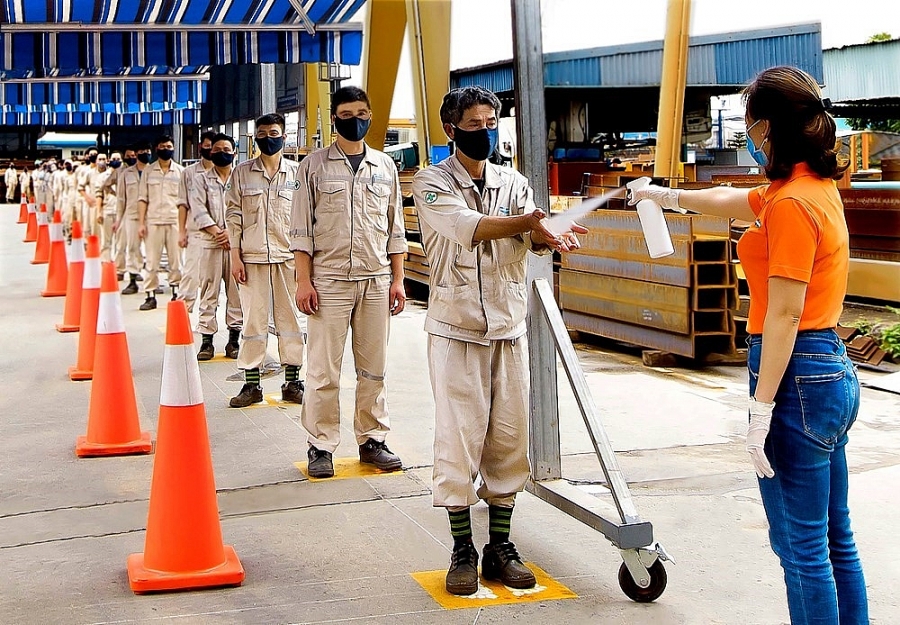 Công nhân của Công ty TNHH Công nghiệp Doosan Hải Phòng đảm bảo giãn cách 2m, thực hiện việc sát khuẩn tay trước khi nghỉ ăn ca.