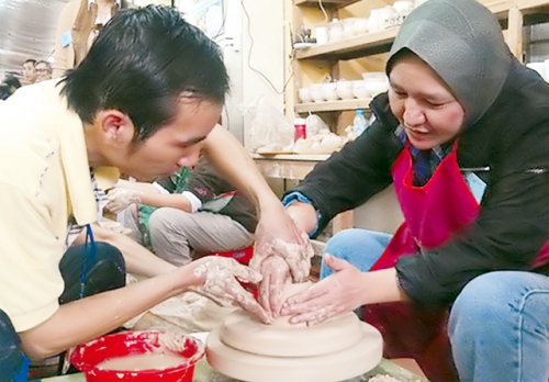 Hướng dẫn khách du lịch trải nghiệm các công đoạn của nghề làm gốm Bát Tràng. Ảnh: NGUYÊN ANH