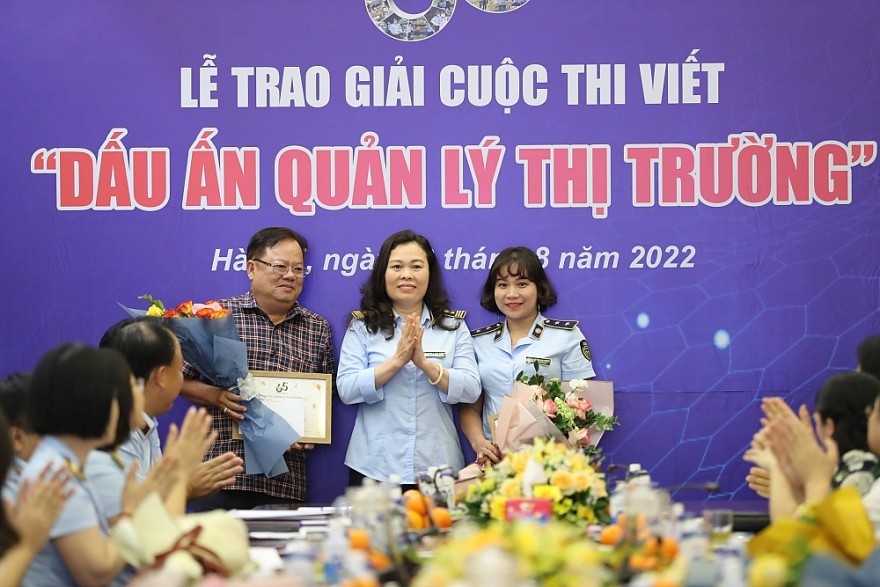 Đại diện Ban tổ chức - Phó Tổng cục trưởng Tổng cục QLTT Chu Thị Thu Hương trao hoa và Giấy chứng nhận cho các tác giả có tác phẩm đạt Giải B trong lực lượng QLTT Đại diện Ban tổ chức - Phó Tổng cục trưởng Tổng cục QLTT Chu Thị Thu Hương trao hoa và Giấy chứng nhận cho các tác giả có tác phẩm đạt Giải B trong lực lượng QLTT