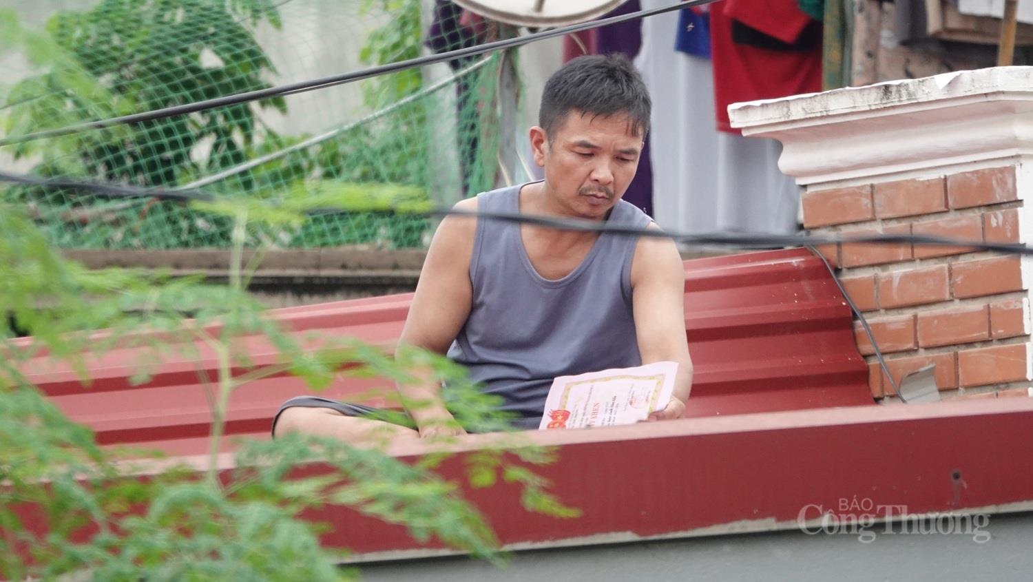 Giữa biển nước, người đàn ông bần thần bên tấm giấy khen ướt sũng của con gái