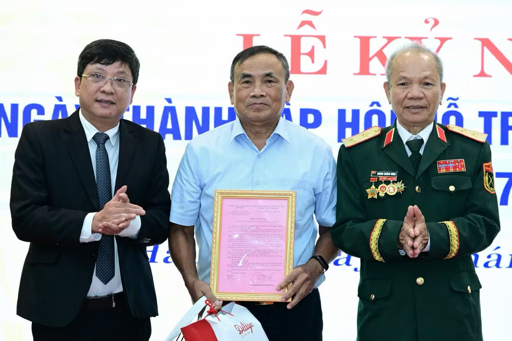 Trung tướng Hoàng Khánh Hưng (ngoài cùng bên phải) trao kết quả giám định ADN cho thân nhân liệt sĩ Trương Thành Ý tại lễ kỷ niệm 15 năm thành lập Hội Hỗ trợ gia đình liệt sĩ Việt Nam. Ảnh: NVCC