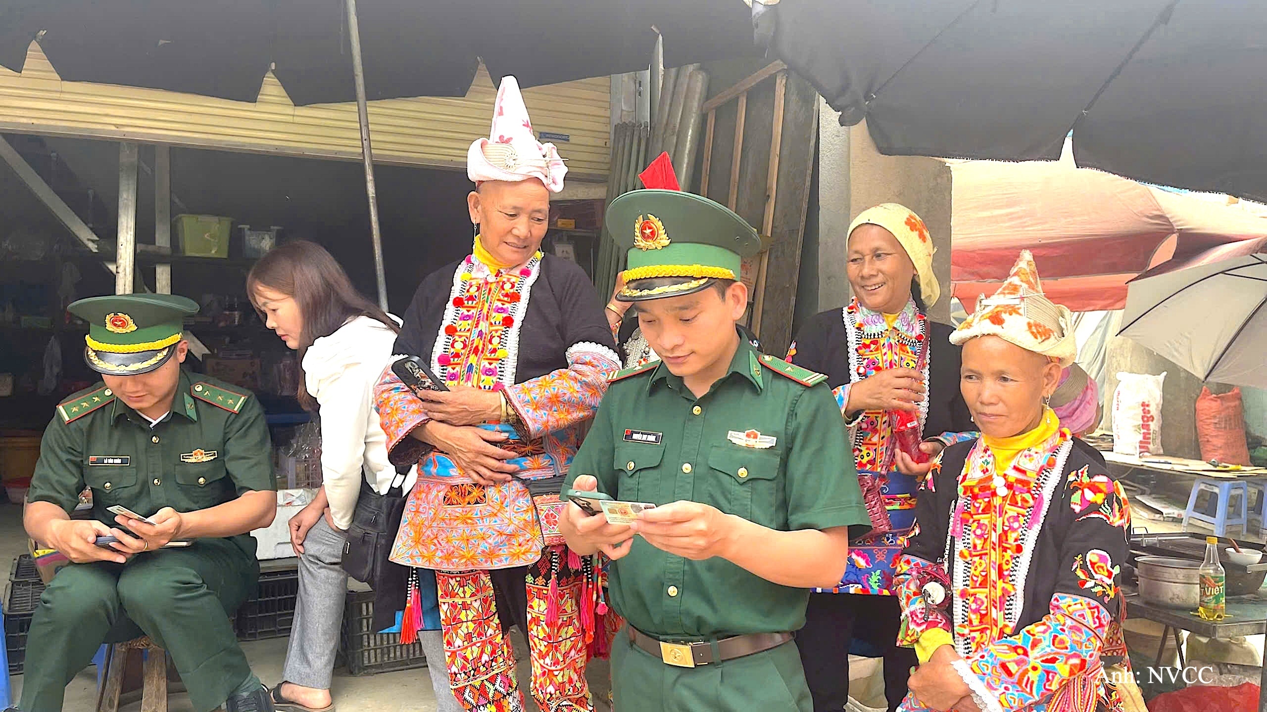 Thiếu tá Nguyễn Duy Khánh cùng tổ công tác hướng dẫn bà con bản Đồng Tiến, xã Sì Lở Lầu cài đặt ứng dụng định danh điện tử trên thiết bị di động.